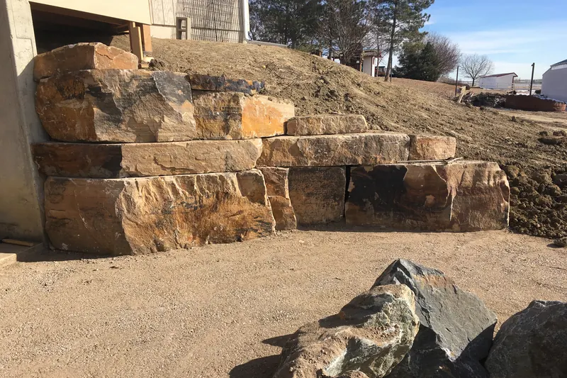 Large boulder retaining wall under construction